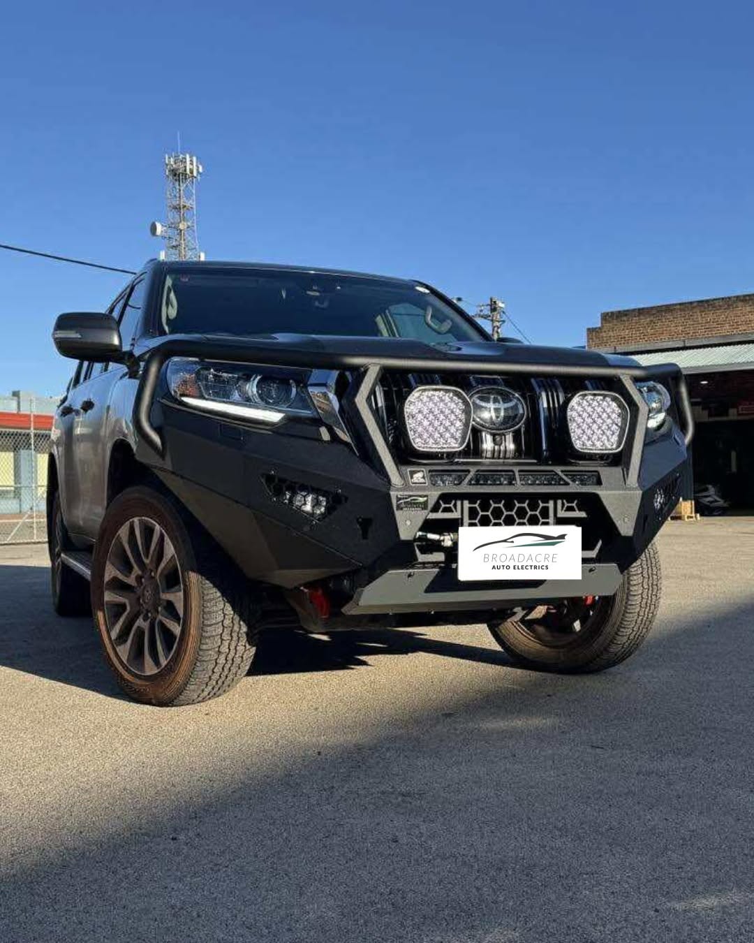 Toyota Prado with a black bull bar and round LED driving lights